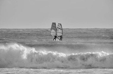 İtalya, Sicilya, Akdeniz, Marina di Ragusa (Ragusa ili); 7 Aralık 2021, denizde rüzgar sörfçüleri - EDITORIAL