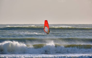 İtalya, Sicilya, Akdeniz, Marina di Ragusa (Ragusa ili); 7 Aralık 2021, denizde rüzgar sörfçüsü - EDITORIAL