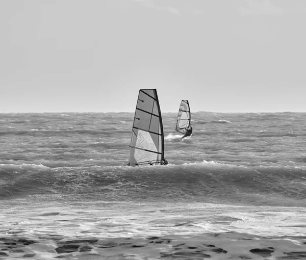 İtalya, Sicilya, Akdeniz, Marina di Ragusa (Ragusa ili); 7 Aralık 2021, denizde rüzgar sörfçüleri - EDITORIAL