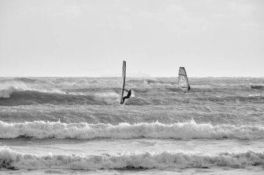 İtalya, Sicilya, Akdeniz, Marina di Ragusa (Ragusa ili); 7 Aralık 2021, denizde rüzgar sörfçüleri - EDITORIAL