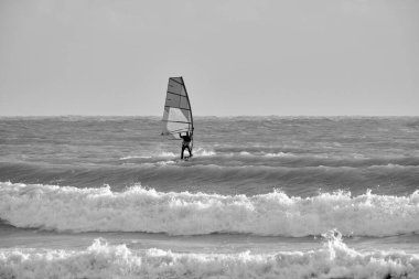 İtalya, Sicilya, Akdeniz, Marina di Ragusa (Ragusa ili); 7 Aralık 2021, denizde rüzgar sörfçüsü - EDITORIAL