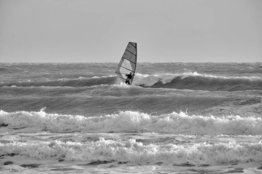 İtalya, Sicilya, Akdeniz, Marina di Ragusa (Ragusa ili); 7 Aralık 2021, denizde rüzgar sörfçüsü - EDITORIAL