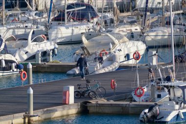 İtalya, Sicilya, Akdeniz, Marina di Ragusa (Ragusa Eyaleti); 3 Ocak 2022, limandaki insanlar ve lüks yatlar - EDITORIAL