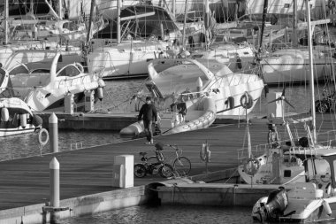 İtalya, Sicilya, Akdeniz, Marina di Ragusa (Ragusa Eyaleti); 3 Ocak 2022, limandaki insanlar ve lüks yatlar - EDITORIAL