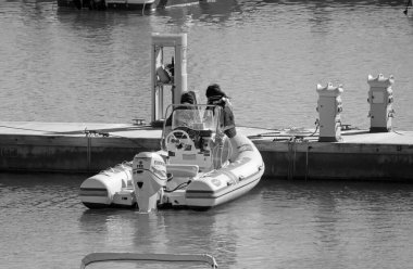 İtalya, Sicilya, Akdeniz, Marina di Ragusa (Ragusa ili); 15 Ocak 2022, limanda bir kauçuk teknede çift - EDITORIAL