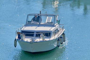 İtalya, Sicilya, Akdeniz, Marina di Ragusa (Ragusa Eyaleti), limanda lüks bir yatta bulunan erkekler 