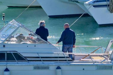 İtalya, Sicilya, Akdeniz, Marina di Ragusa (Ragusa ili); 15 Ocak 2022, erkekler limanda lüks bir yatta - EDITORIAL