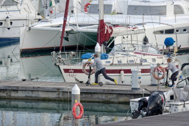 Taly, Sicilya, Akdeniz, Marina di Ragusa (Ragusa Eyaleti); 22 Ocak 2022, limanda motorlu ve lüks yatlı çocuklar