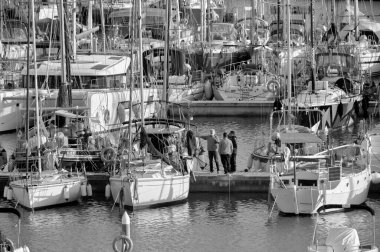İtalya, Sicilya, Akdeniz, Marina di Ragusa (Ragusa Eyaleti); 6 Şubat 2022, limandaki insanlar ve yelkenliler - EDITORIAL