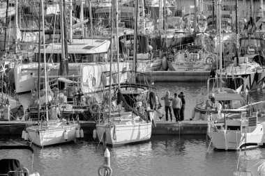 İtalya, Sicilya, Akdeniz, Marina di Ragusa (Ragusa Eyaleti); 6 Şubat 2022, limandaki insanlar ve yelkenliler - EDITORIAL
