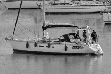 İtalya, Sicilya, Akdeniz, Marina di Ragusa (Ragusa Eyaleti); 13 Şubat 2022, limandaki bir yelkenli teknesinde insanlar - EDITORIAL