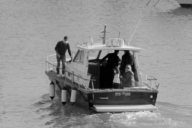 İtalya, Sicilya, Akdeniz, Marina di Ragusa (Ragusa Eyaleti); 14 Şubat 2022, limanda lüks bir yatta insanlar - EDITORIAL