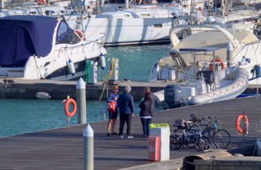 İtalya, Sicilya, Akdeniz, Marina di Ragusa (Ragusa Eyaleti); 21 Şubat 2022, limanda halk, bisiklet ve lüks yatlar - EDITORIAL