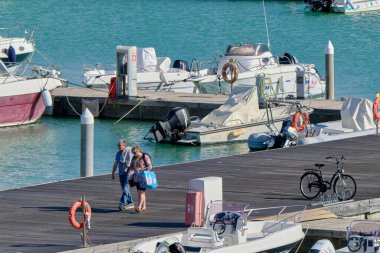 İtalya, Sicilya, Akdeniz, Marina di Ragusa (Ragusa ili); 23 Şubat 2022, limandaki insanlar, motorlu tekneler ve lüks yatlar - EDITORIAL