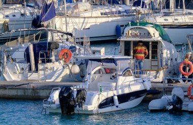 İtalya, Sicilya, Akdeniz, Marina di Ragusa (Ragusa Eyaleti); 27 Şubat 2022, limanda lüks bir yatta adam - EDITORIAL