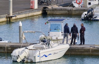 İtalya, Sicilya, Akdeniz, Marina di Ragusa (Ragusa Eyaleti); 4 Mart 2022, limandaki insanlar, motorlu tekneler ve lüks yatlar - EDITORIAL