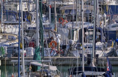 İtalya, Sicilya, Akdeniz, Marina di Ragusa (Ragusa Eyaleti); 11 Mart 2022, limanda yelkenli tekneleri ve lüks yatlarda insanlar - EDITORIAL