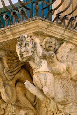 İtalya, Sicilya, Scicli (Ragusa ili), Unesco Baroque Fava Sarayı cephesi, bir balkon altında süslü heykeller (M.S. 18..)
