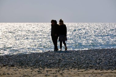 İtalya, Sicilya, Playa Grande (Ragusa Eyaleti); sahilde yürüyen çift