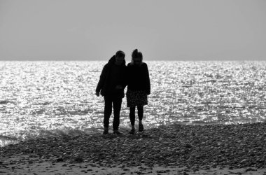 İtalya, Sicilya, Playa Grande (Ragusa Eyaleti); sahilde yürüyen çift