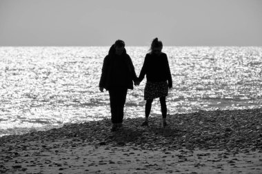 İtalya, Sicilya, Playa Grande (Ragusa Eyaleti); sahilde yürüyen çift