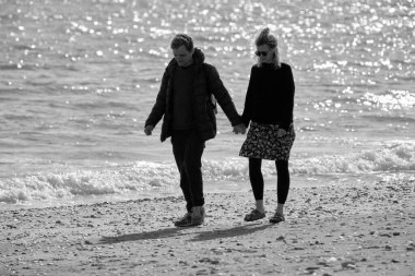 İtalya, Sicilya, Playa Grande (Ragusa Eyaleti); 24 Mart 2022, plajda yürüyen çift - EDITORIAL