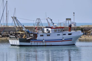 İtalya, Sicilya, Scoglitti (Ragusa Eyaleti); limandaki ahşap bir balıkçı teknesinde balıkçılar 