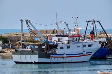 İtalya, Sicilya, Scoglitti (Ragusa Eyaleti); limandaki ahşap bir balıkçı teknesinde balıkçılar 