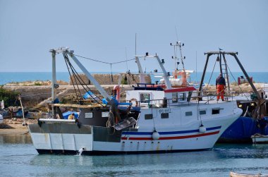 İtalya, Sicilya, Scoglitti (Ragusa Eyaleti); limandaki ahşap bir balıkçı teknesinde balıkçılar 
