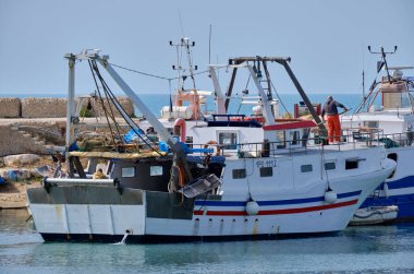 İtalya, Sicilya, Scoglitti (Ragusa Eyaleti); limandaki ahşap bir balıkçı teknesinde balıkçılar 