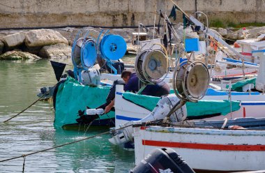 İtalya, Sicilya, Akdeniz, Scoglitti (Ragusa ili); 29 Mart 2022, limanda ahşap bir balıkçı teknesinde çalışan balıkçı - EDITORIAL