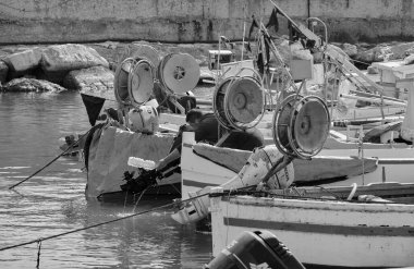 İtalya, Sicilya, Akdeniz, Scoglitti (Ragusa ili); 29 Mart 2022, limanda ahşap bir balıkçı teknesinde çalışan balıkçı - EDITORIAL