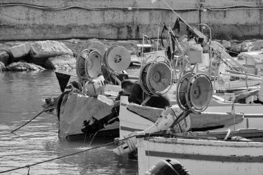 İtalya, Sicilya, Akdeniz, Scoglitti (Ragusa ili); 29 Mart 2022, limanda ahşap bir balıkçı teknesinde çalışan balıkçı - EDITORIAL