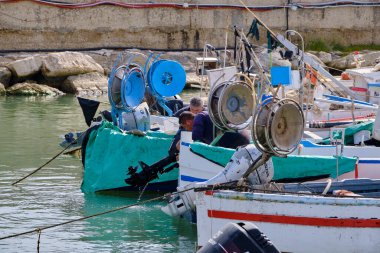 İtalya, Sicilya, Akdeniz, Scoglitti (Ragusa Eyaleti); 29 Mart 2022, limanda ahşap bir balıkçı teknesinde çalışan balıkçılar