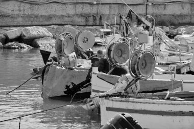 İtalya, Sicilya, Akdeniz, Scoglitti (Ragusa Eyaleti); 29 Mart 2022, limanda ahşap bir balıkçı teknesinde çalışan balıkçılar