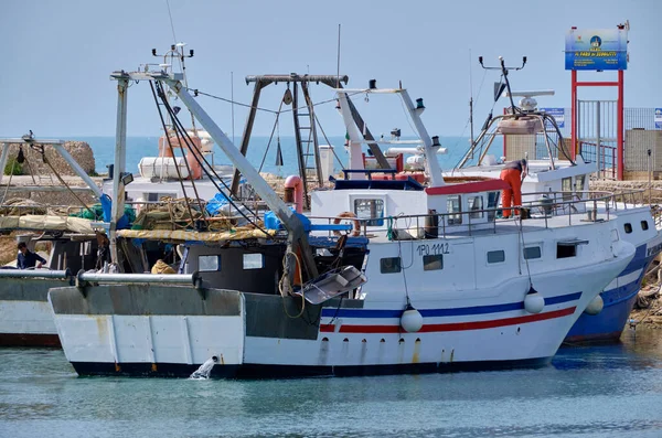 İtalya, Sicilya, Scoglitti (Ragusa Eyaleti); limandaki ahşap bir balıkçı teknesinde balıkçılar 