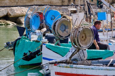 İtalya, Sicilya, Akdeniz, Scoglitti (Ragusa Eyaleti); 29 Mart 2022, limanda ahşap bir balıkçı teknesinde çalışan balıkçılar