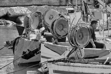 İtalya, Sicilya, Akdeniz, Scoglitti (Ragusa Eyaleti); 29 Mart 2022, limanda ahşap bir balıkçı teknesinde çalışan balıkçılar