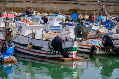İtalya, Sicilya, Akdeniz, Scoglitti (Ragusa Eyaleti); 29 Mart 2022, limandaki yerel ahşap balıkçı tekneleri ve balıkçılar - EDITORIAL