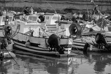 İtalya, Sicilya, Akdeniz, Scoglitti (Ragusa Eyaleti); 29 Mart 2022, limandaki yerel ahşap balıkçı tekneleri ve balıkçılar - EDITORIAL