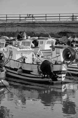 İtalya, Sicilya, Akdeniz, Scoglitti (Ragusa Eyaleti); 29 Mart 2022, limandaki yerel ahşap balıkçı tekneleri ve balıkçılar - EDITORIAL