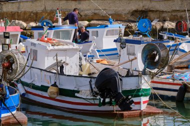 İtalya, Sicilya, Akdeniz, Scoglitti (Ragusa Eyaleti); 29 Mart 2022, limandaki yerel ahşap balıkçı tekneleri ve balıkçılar - EDITORIAL