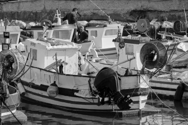 İtalya, Sicilya, Akdeniz, Scoglitti (Ragusa Eyaleti); 29 Mart 2022, limandaki yerel ahşap balıkçı tekneleri ve balıkçılar - EDITORIAL