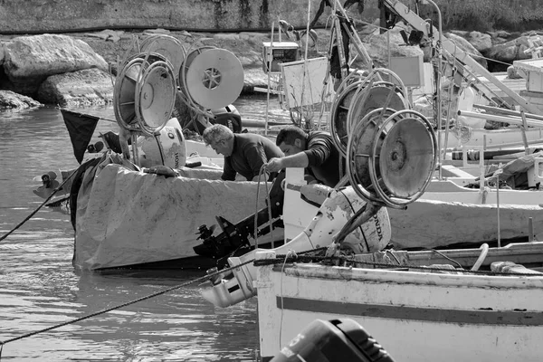 İtalya, Sicilya, Akdeniz, Scoglitti (Ragusa Eyaleti); 29 Mart 2022, limanda ahşap bir balıkçı teknesinde çalışan balıkçılar