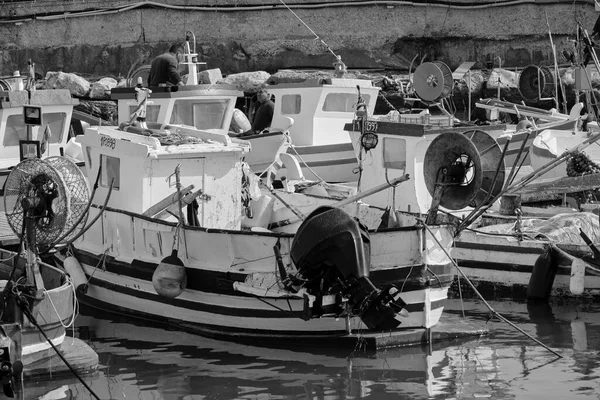 İtalya, Sicilya, Akdeniz, Scoglitti (Ragusa Eyaleti); 29 Mart 2022, limandaki yerel ahşap balıkçı tekneleri ve balıkçılar - EDITORIAL