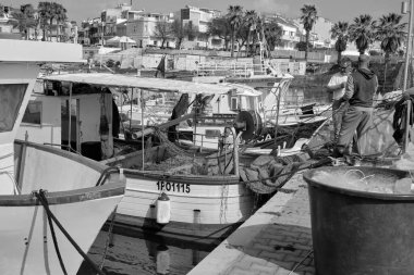 İtalya, Sicilya, Akdeniz, Scoglitti (Ragusa Eyaleti); 29 Mart 2022, limandaki yerel ahşap balıkçı tekneleri ve balıkçılar - EDITORIAL