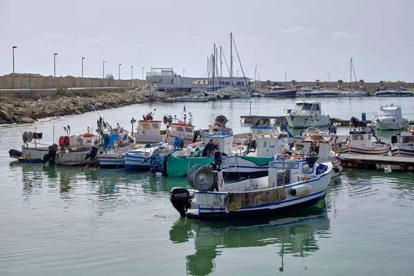 İtalya, Sicilya, Akdeniz, Scoglitti (Ragusa Eyaleti); 29 Mart 2022, limandaki yerel ahşap balıkçı tekneleri ve balıkçılar - EDITORIAL
