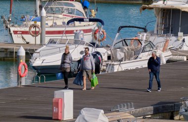 İtalya, Sicilya, Akdeniz, Marina di Ragusa (Ragusa Eyaleti); 3 Nisan 2022, limandaki insanlar ve lüks yatlar - EDITORIAL