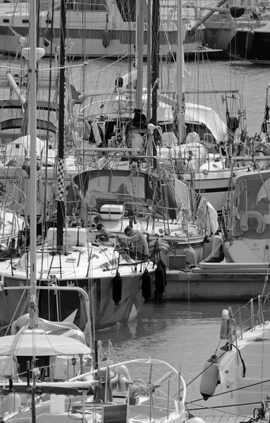 İtalya, Sicilya, Akdeniz, Marina di Ragusa (Ragusa Eyaleti); 6 Nisan 2022, limandaki bir yelkenli ve lüks yatlarda erkekler - EDITORIAL