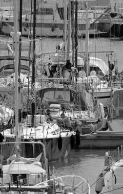 İtalya, Sicilya, Akdeniz, Marina di Ragusa (Ragusa Eyaleti); 6 Nisan 2022, limandaki bir yelkenli ve lüks yatlarda erkekler - EDITORIAL